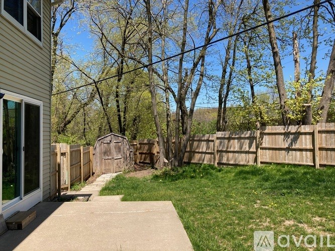 A backyard with a wooden fence and a shed.