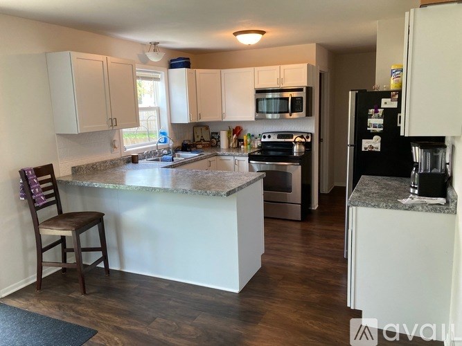 A kitchen with a refrigerator, stove, and cabinets.
