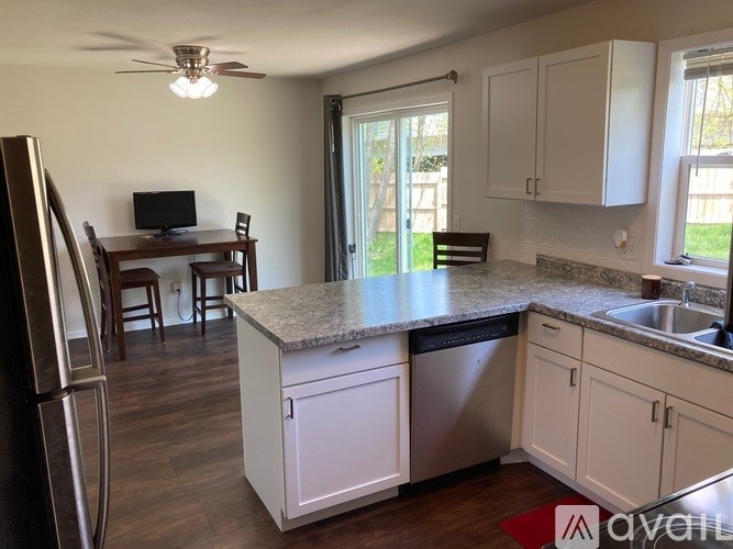 A kitchen with white cabinets and a granite countertop.