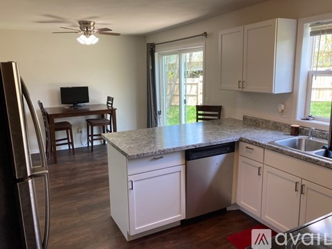 A kitchen with white cabinets and a granite countertop.
