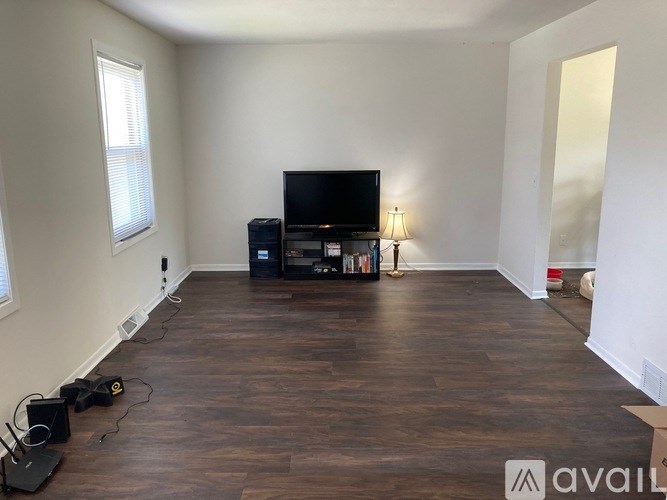A room with a television, speakers, and a bookshelf.