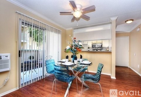 A dining room with a table set for six and a ceiling fan.