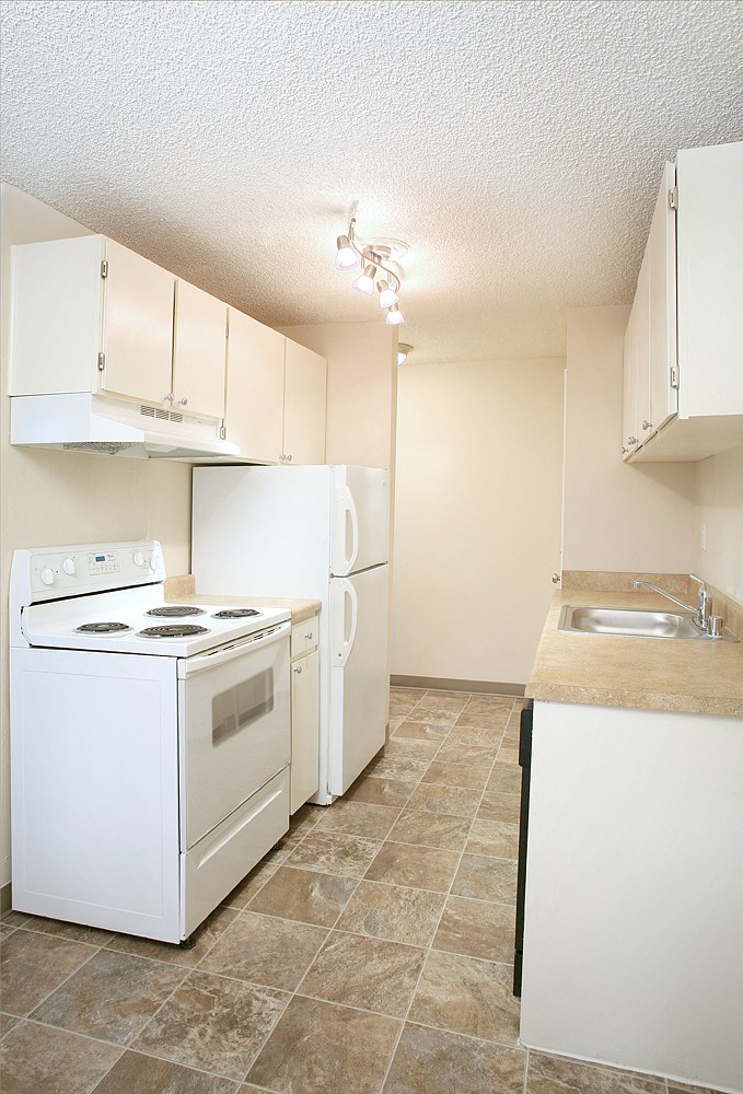an empty kitchen with a stove refrigerator and sink