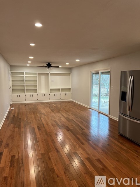 A room with wooden flooring and a ceiling fan.