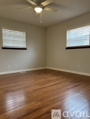 A room with wooden floors and a ceiling fan.