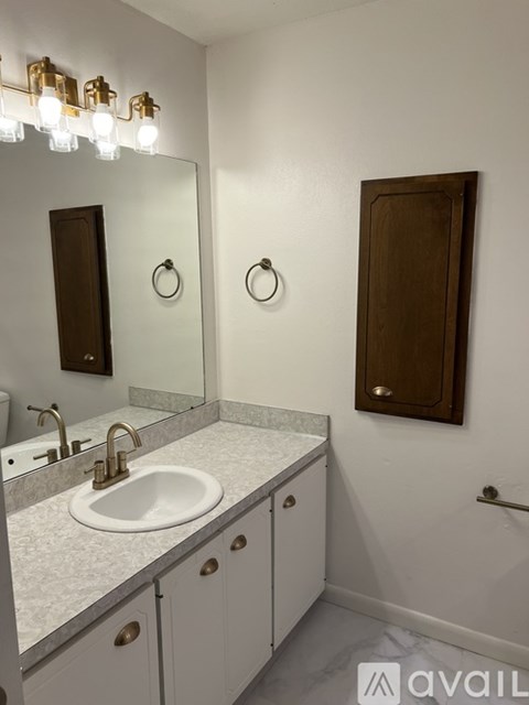 A bathroom with a sink, mirror, and a wooden door.