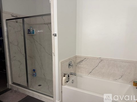 A bathroom with a marble tub and shower.