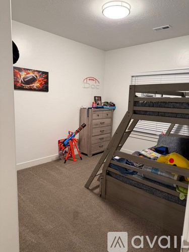 A room with a bunk bed and a dresser with a toy on the floor.