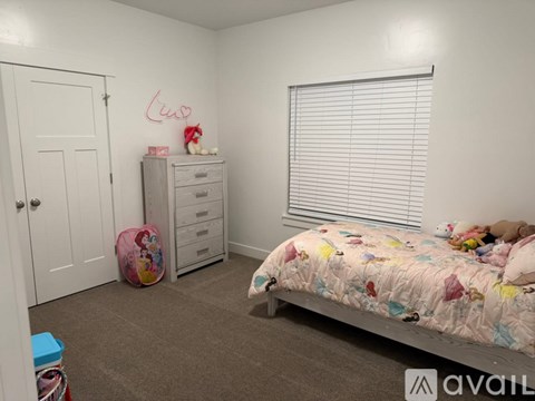 A child's bedroom with a bed, dresser, and a wall with the word "Luna" written on it.