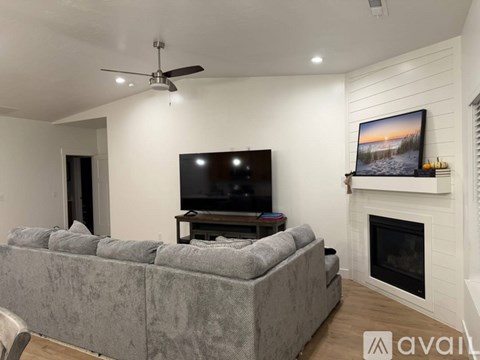 A grey couch is in front of a television in a living room.