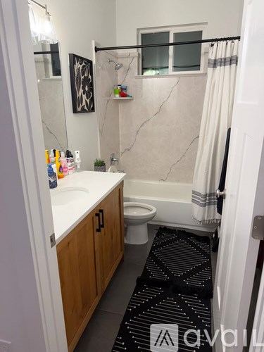 A bathroom with a sink, toilet, and a shower curtain.