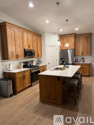 A kitchen with wooden cabinets and a white island.