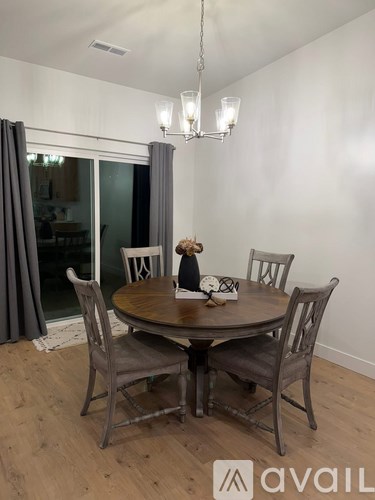 A dining room with a round table and chairs.