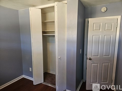 A white closet with a door and shelves is shown.