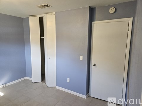 A room with a white door and a grey wall.