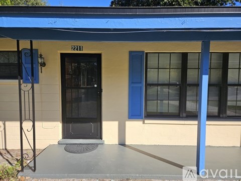 A house numbered 2211 is shown with a black door and a blue awning.