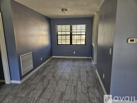 A room with a window and a tiled floor.