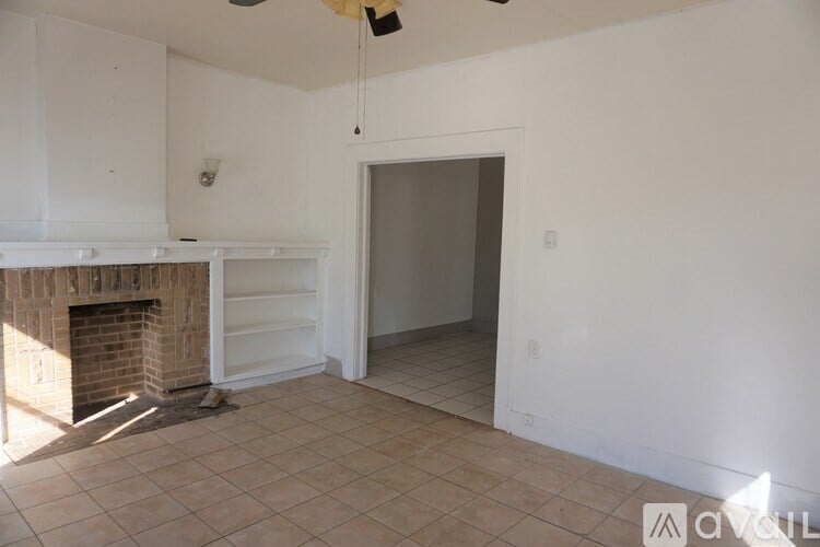 A room with a fireplace and a ceiling fan.
