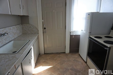 A kitchen with a sink, stove, and refrigerator.