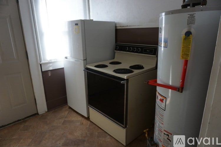 A kitchen with a white fridge, a white oven, and a white door.