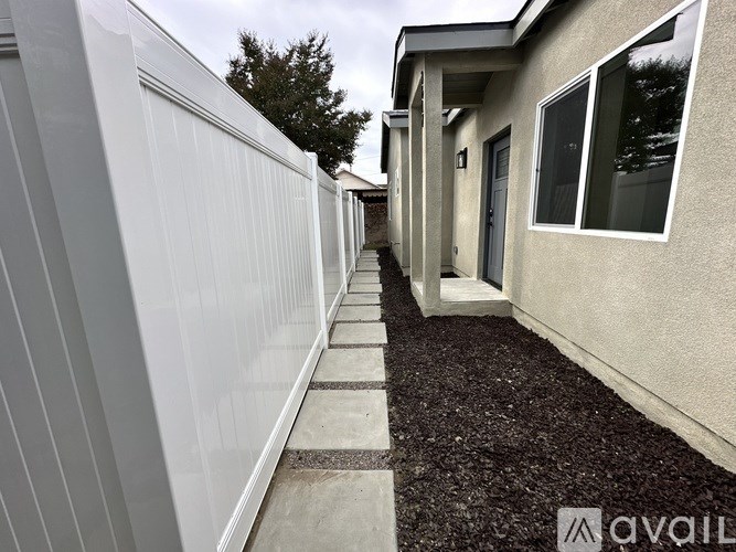 A white fence runs along the side of a house.