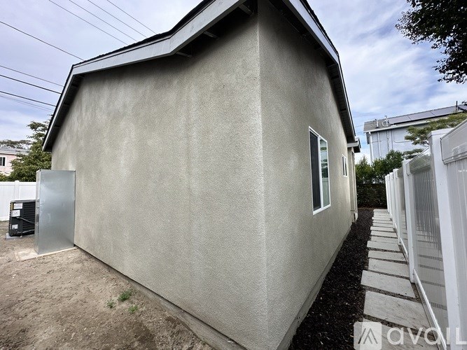 A small house with a grey exterior and a white door.