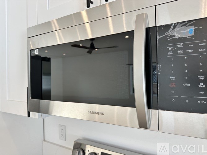 A Samsung microwave with a digital display and control panel.