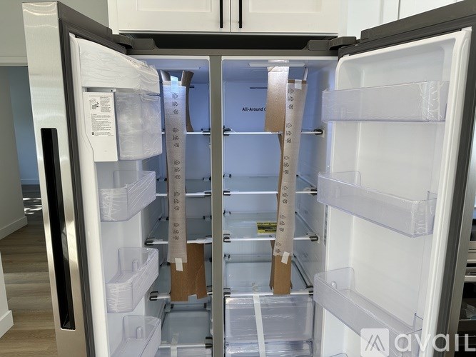 A white refrigerator with a few shelves and a few boxes on the shelves.