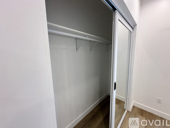 A white closet with a white door and a white wall.