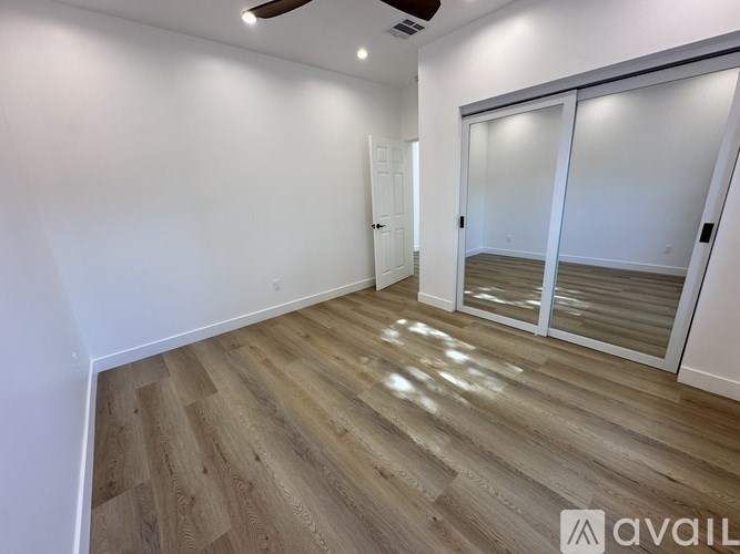 A room with wooden flooring and a ceiling fan.