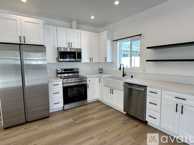 A kitchen with white cabinets and stainless steel appliances.