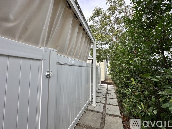 A row of white fences with a sign that says "AVAILABLE" in the foreground.