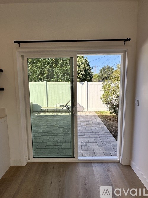 A patio with a glass door leading to a backyard.