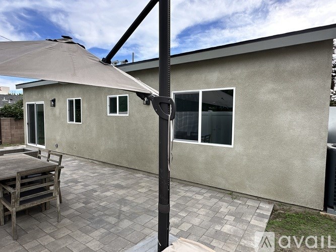 A patio with a table and chairs under an umbrella.