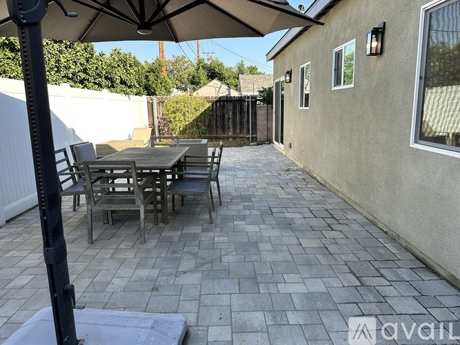 A patio with a table and chairs under an umbrella.