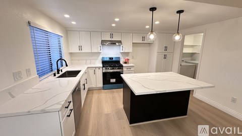 A modern kitchen with white cabinets and a large island.