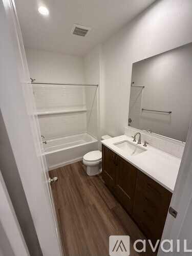 A bathroom with a toilet, sink, and a walk-in shower.