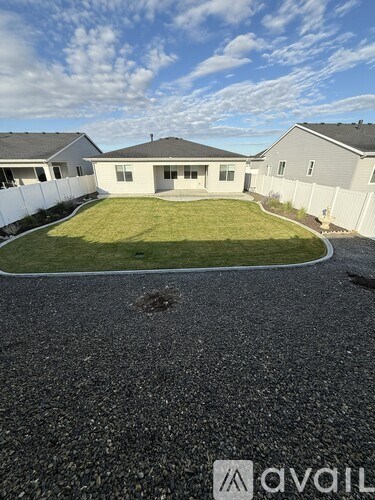 A house with a gravel driveway in front of it.