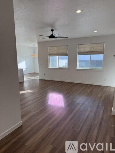 A room with wooden flooring and a ceiling fan.