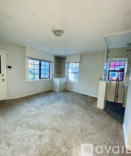 A room with a carpeted floor and a window.