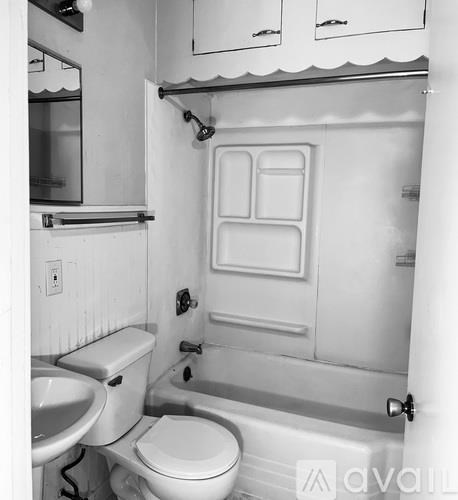A white bathroom with a toilet, sink, and shower.