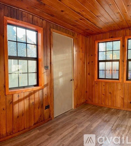 A room with wooden walls and a white door.