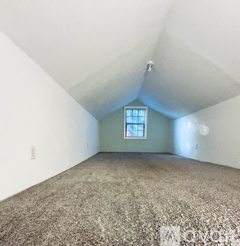 A room with a window and carpeted floor.