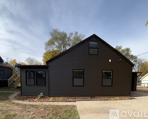 A house with a brown siding and a pitched roof is available for rent.
