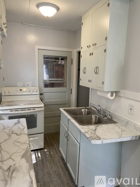 A kitchen with a white oven and sink.