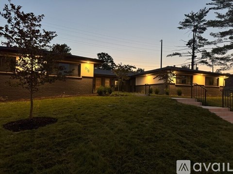 A building with the sign "S8" is lit up at dusk with a tree in the foreground.