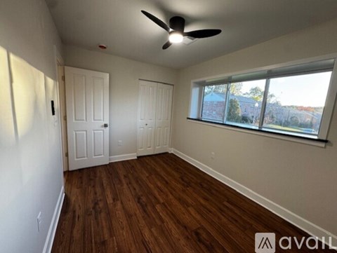 A room with a ceiling fan and two doors.