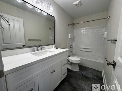 A bathroom with a sink, toilet, and shower.