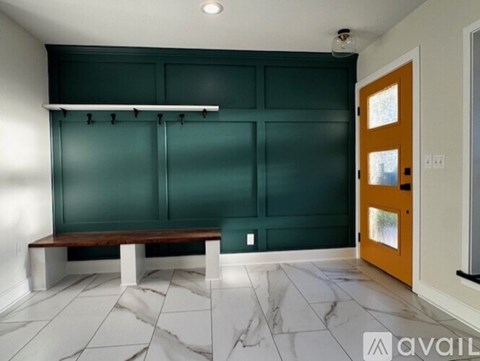 A room with a bench and a door.