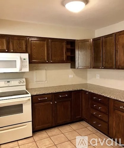 A kitchen with brown cabinets and a white oven.